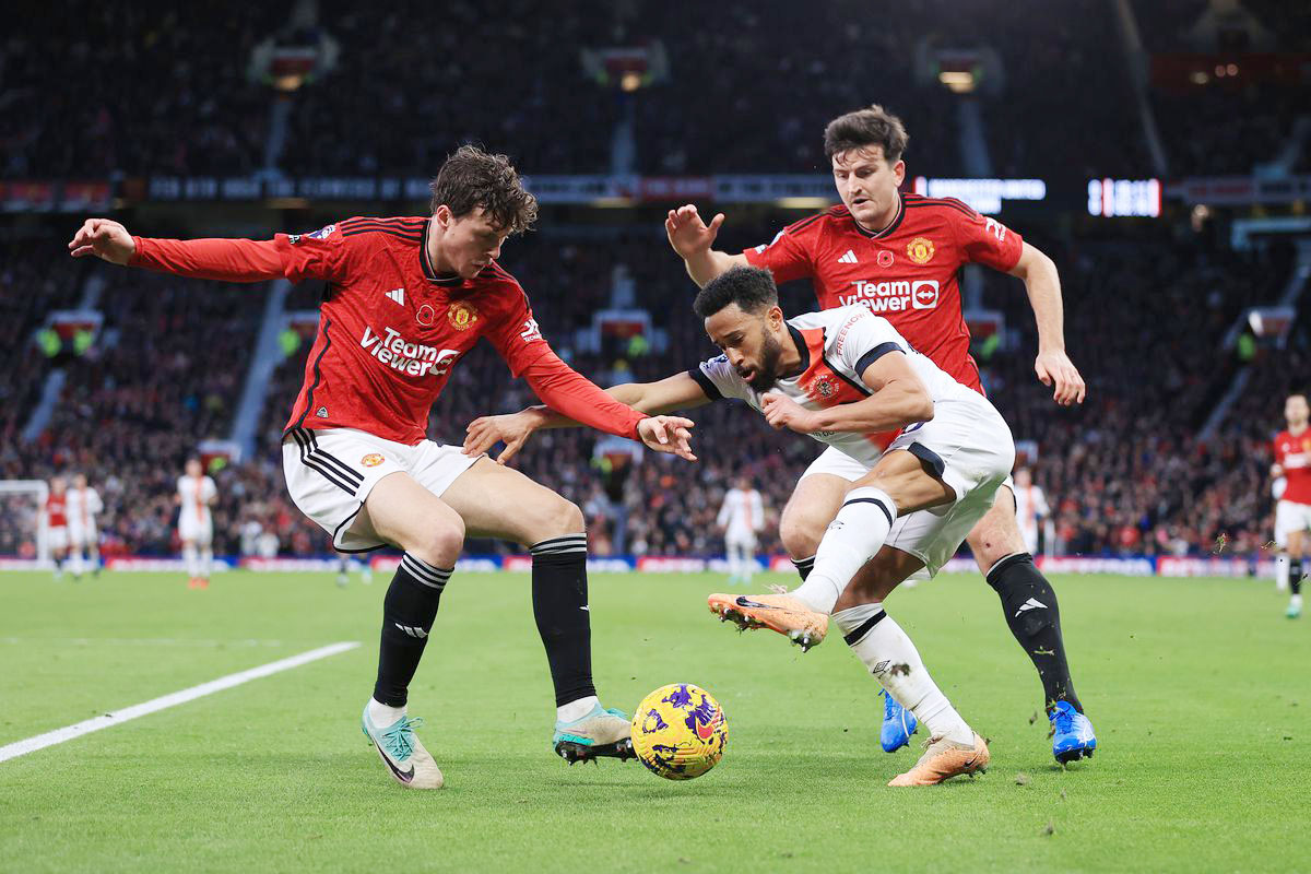 Manchester United players competing in a game against Luton Town. Exciting soccer action on display